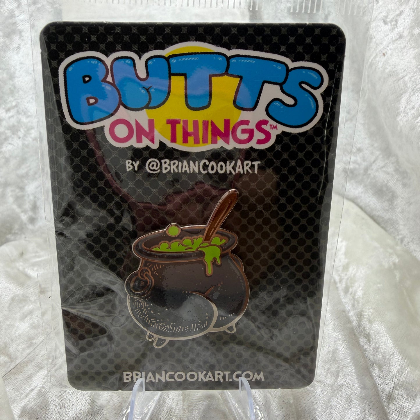 Cauldron Butt Pin by Brian Cook funny glow-in-the-dark spooky parody enamel pin on backing card