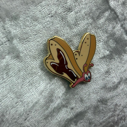 1.25 inch Bread and Butterfly Alice in Wonderland style enamel pin designed by Unicorn Crafts.