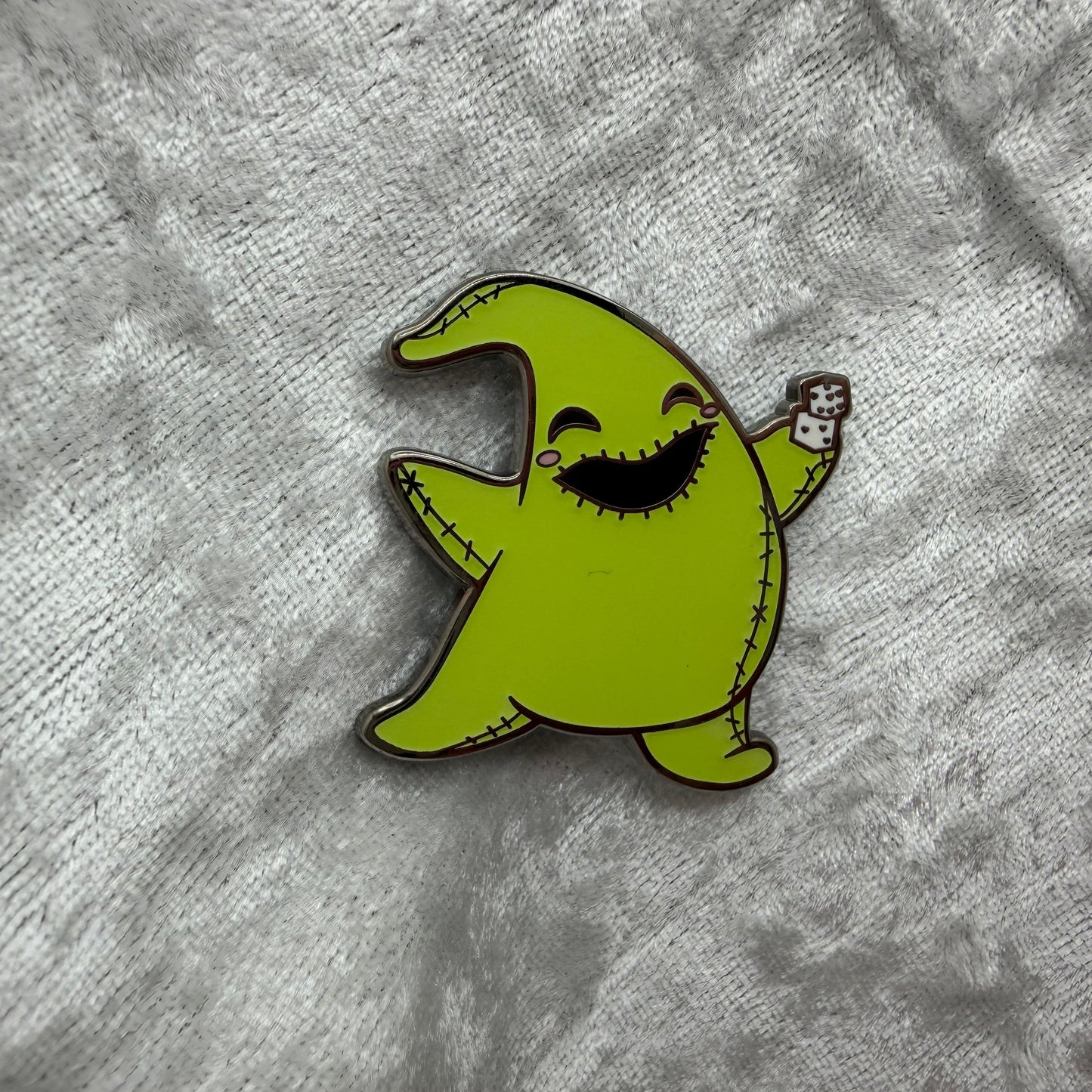 1.25 inch glow in the dark Oogie Boogie style cartoon enamel pin designed by Unicorn Crafts.