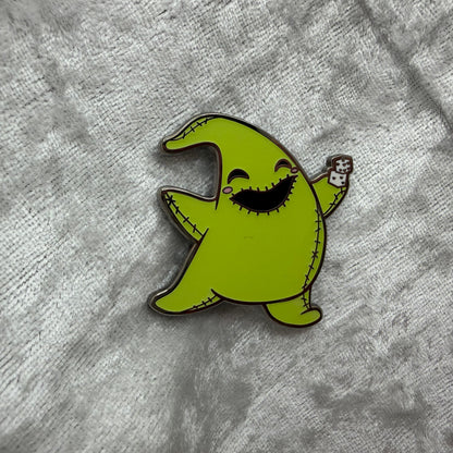 1.25 inch glow in the dark Oogie Boogie style cartoon enamel pin designed by Unicorn Crafts.