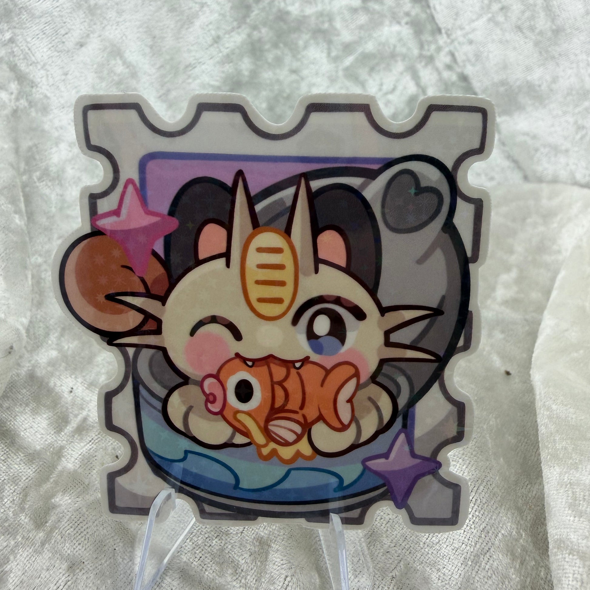 A cute 2.5-inch cat poke stamp vinyl sticker featuring a playful cat and fish design with a shimmering star holographic finish.