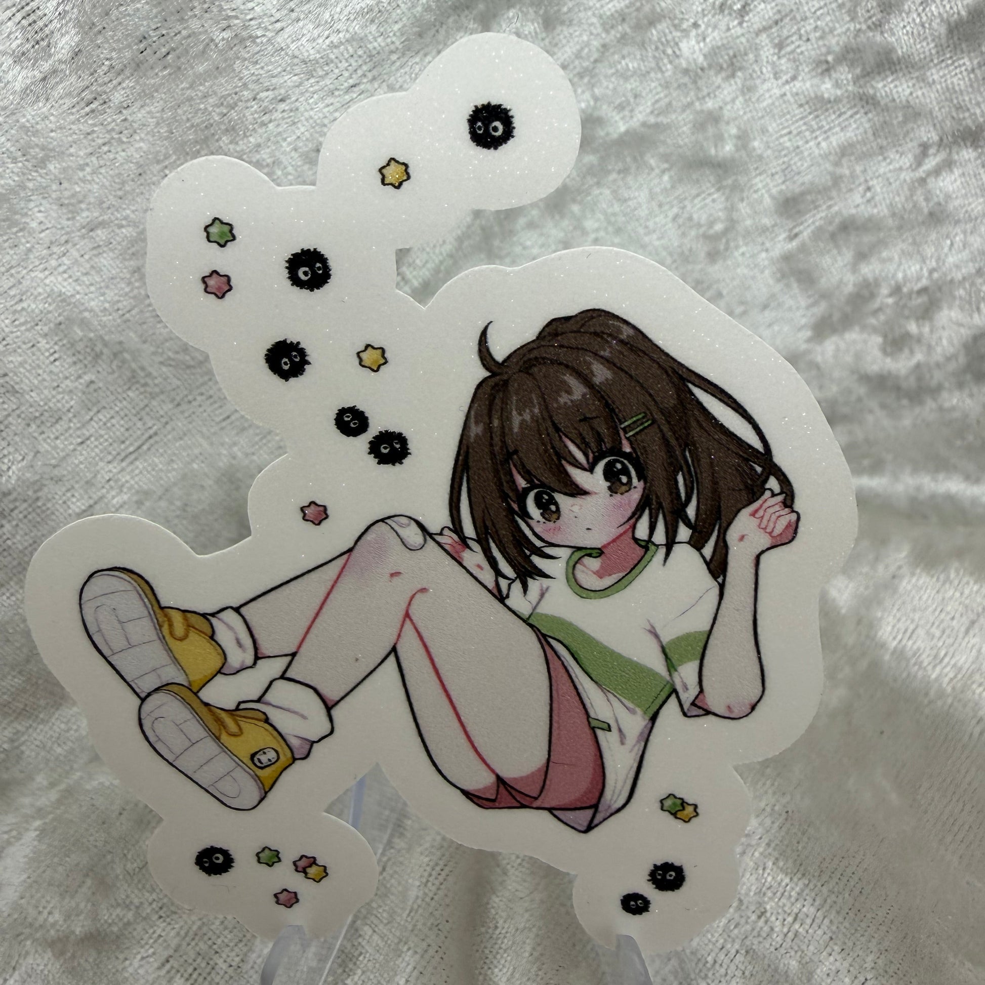 A vinyl sticker of Chi from the Studio Girls collection with a textured sand glitter sparkle laminate finish on a white background.