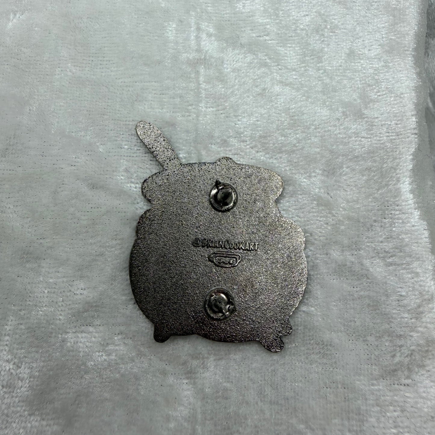 Back of Brian Cook Cauldron Butt parody enamel pin