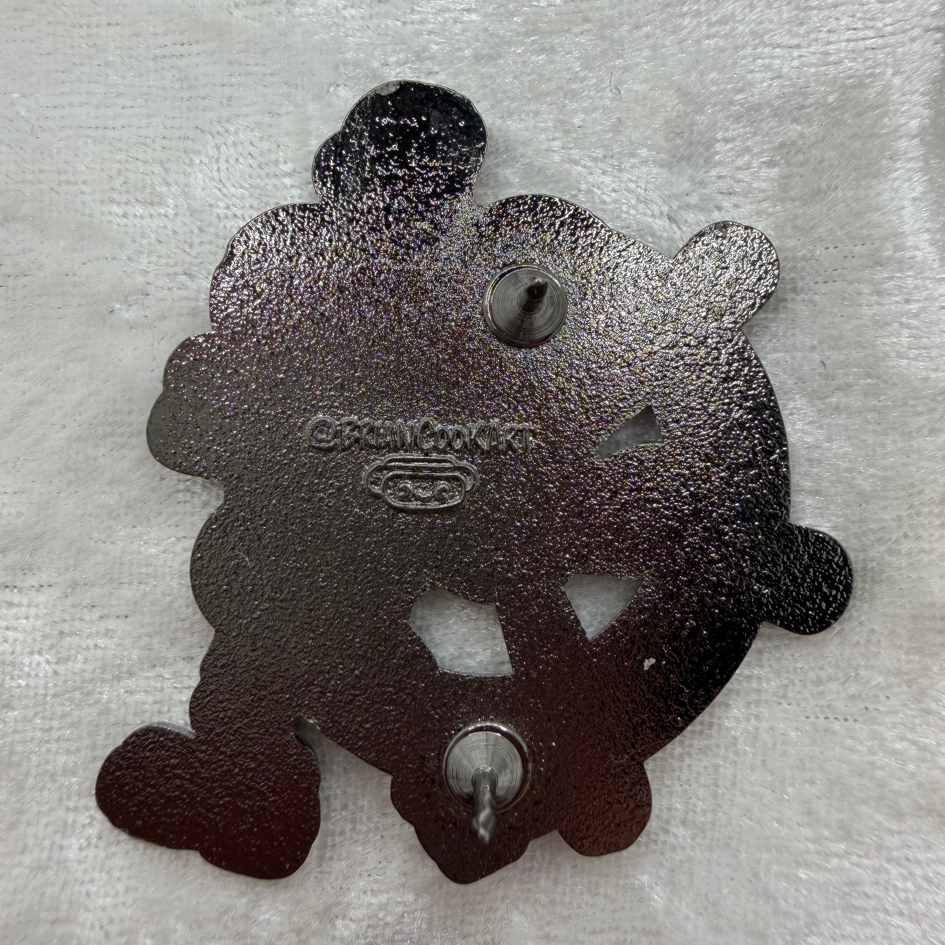 Back of Brian Cook Steambutt Willie parody enamel pin