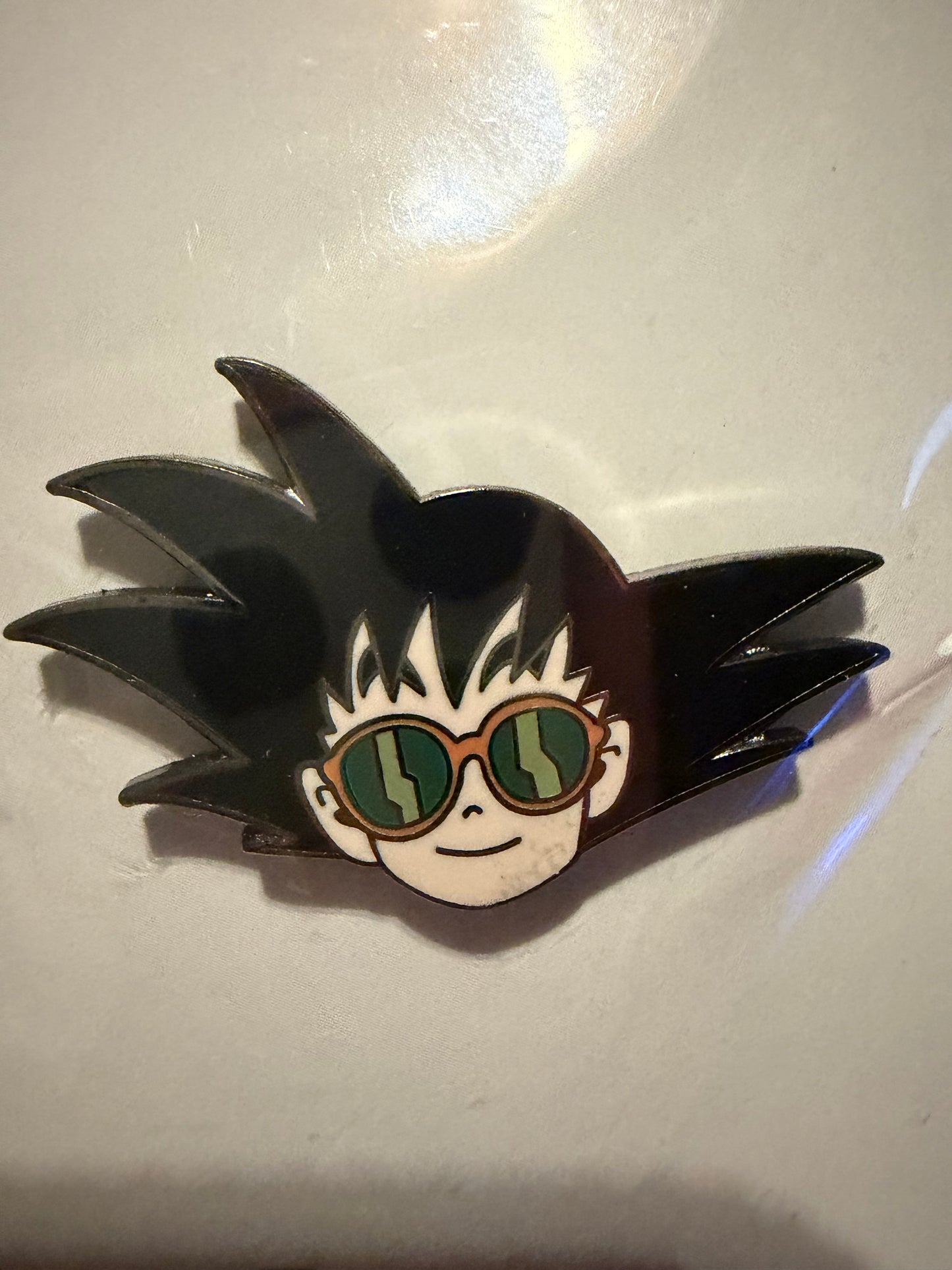 Close-up of Goku Chillin Enamel Pin, showing vibrant epoxy finish and black nickel metal detail. Dragon Ball Z collectible by Hype Pins.