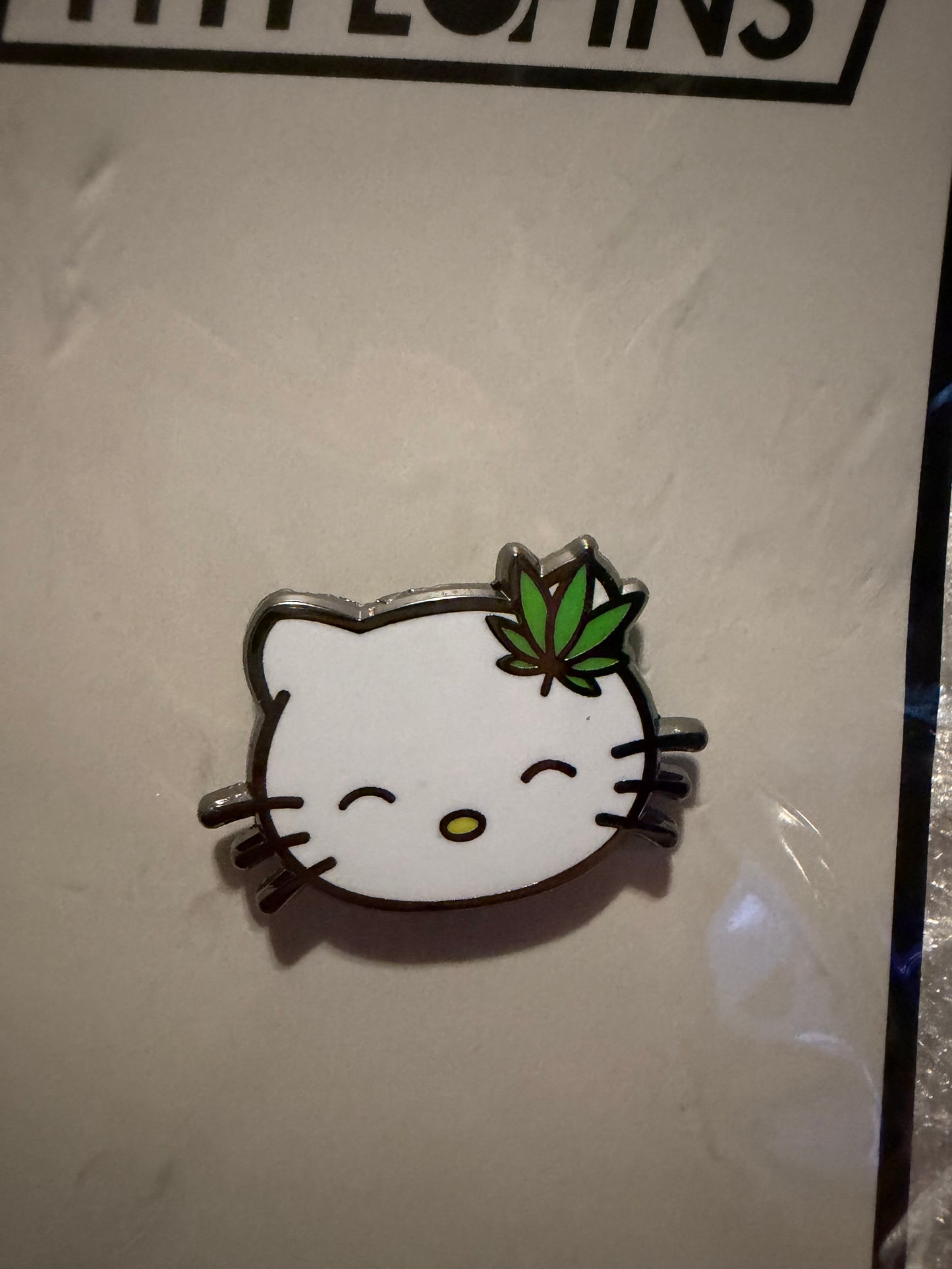 Close-up of the **Hello Litty Hard Enamel Pin**, showing vibrant colors, sleek hard enamel finish, and black nickel metal detail. A unique art collectible by Hype Pins.