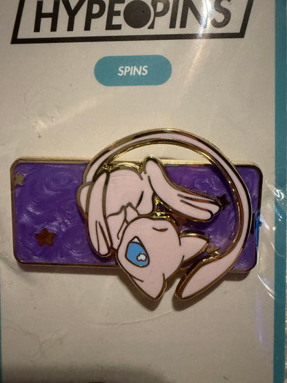 Close-up of the **Mew Galaxy Spinning Hard Enamel Pin**, showcasing its intricate glitter, stirred pearl effect, gold plating, and the legendary Pokémon Mew in its cosmic design.