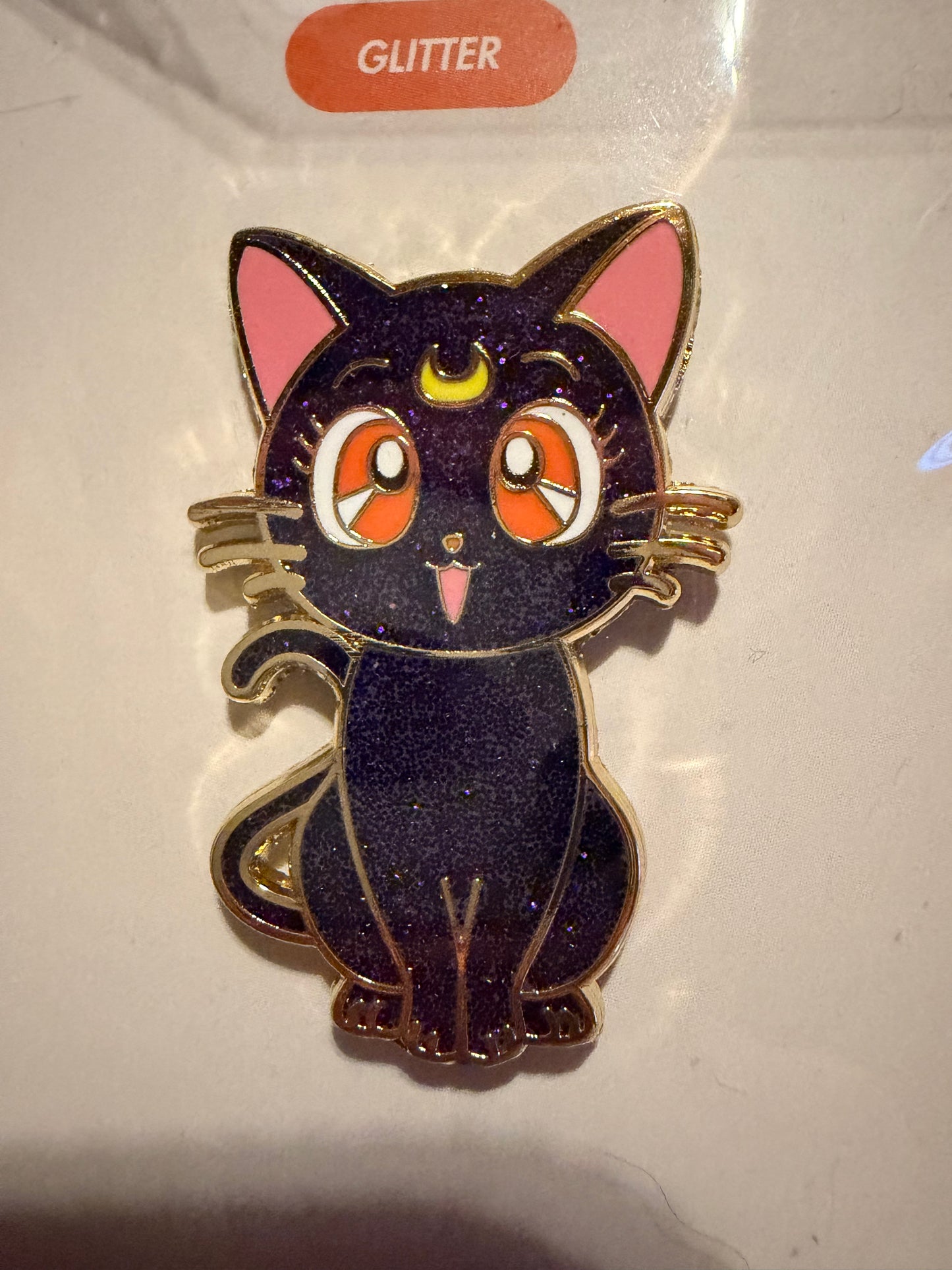 Close-up of the **Sailor Moon Cat Luna Hard Enamel Pin**, highlighting its wise expression, sleek hard enamel finish, and luxurious **gold plating**. A detailed anime collectible by Hype Pins.