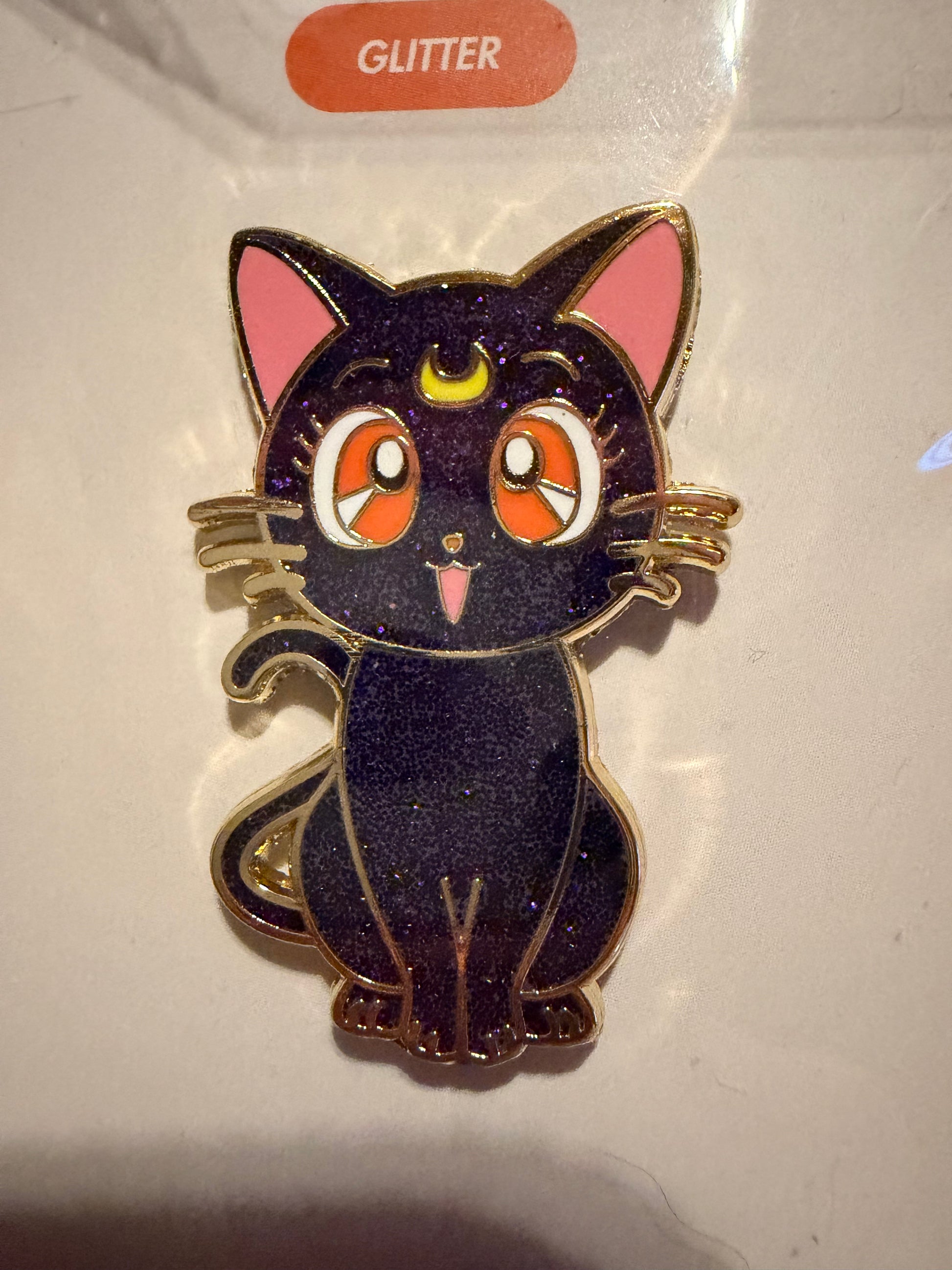 Close-up of the **Sailor Moon Cat Luna Hard Enamel Pin**, highlighting its wise expression, sleek hard enamel finish, and luxurious **gold plating**. A detailed anime collectible by Hype Pins.
