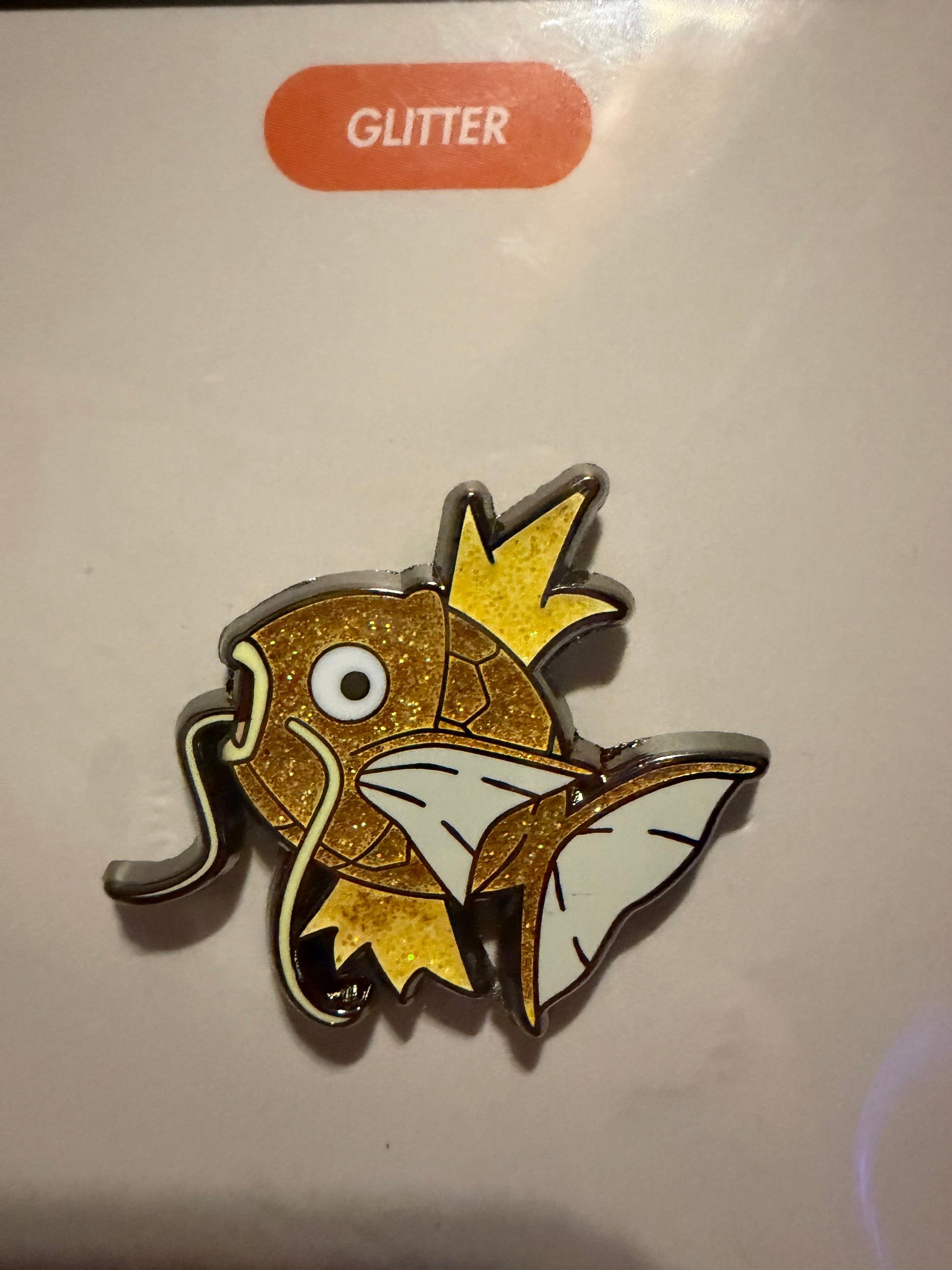 Close-up of the **Shiny Magikarp Hard Enamel Pin**, highlighting its unique golden scales, vibrant colors, and sleek hard enamel finish. A detailed Pokémon collectible by Hype Pins.