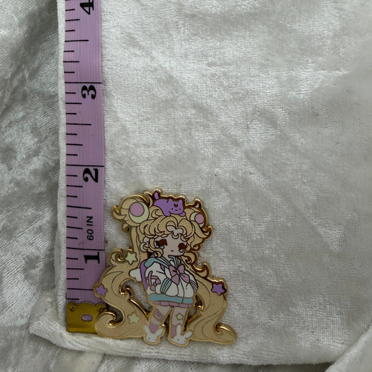 Moon Brat enamel pin placed next to a measuring tape showing its exact height of 1.80 inches.