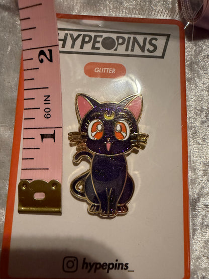 Sailor Moon Cat Luna Hard Enamel Pin by Hype Pins, displayed next to a tape measure to show its **1.5-inch size**. This iconic anime collectible features **gold plating** and a durable hard enamel finish.