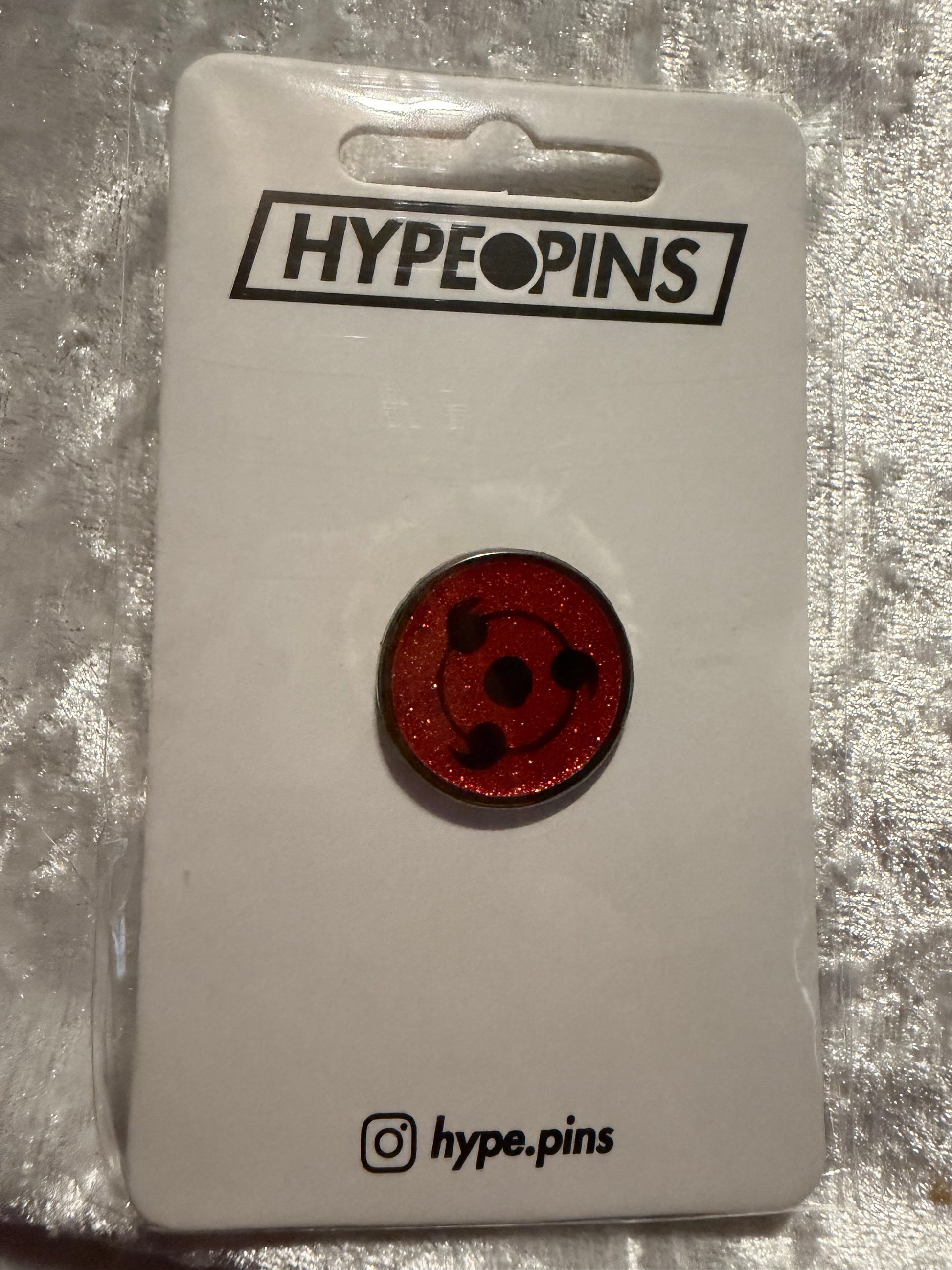 The **Sharingan Obito Hard Enamel Pin**, a compact and powerful **Naruto Uchiha collectible** by Hype Pins, showcasing Obito's iconic Sharingan eye.