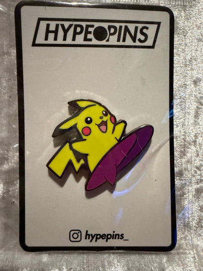 The **Surfing Pikachu Hard Enamel Pin**, a vibrant **Pokémon collectible** by Hype Pins, featuring Pikachu expertly riding a wave, perfect for any fan's collection.